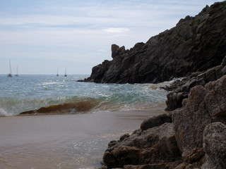 Fototapeta na wymiar Une plage de sables fin avec la côte rocheuse surplombant la mer