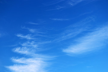 Blue sky covered with white cirrus clouds. Spring cloudscape, beautiful weather background, abstract pattern