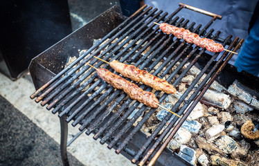 Grilled kebab cooking on wooden skewers