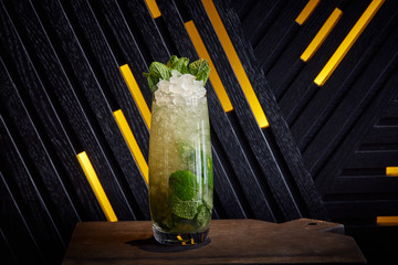 fresh mojito cocktail with lime, mint and ice in glass on dark minimalist design background, summer cold drink and cocktail, minimalism, copy space 