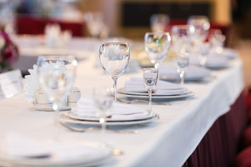 Fototapeta na wymiar Table settings with white wine glasses and glasses of spirits. Wedding decor, restaurant layout.