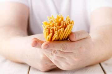 Hand full of raw dry spaghetti, close up view