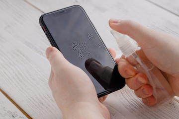 Covid 19 prevention applying alkohol desinfection to mobile phone