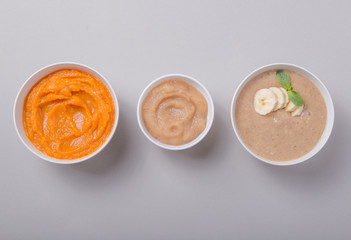 Bowls with healthy baby food on color background. Purees, made of fresh organic fruit and vegetables, flay lay, top view, concept. Kids meal
