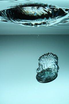 Close-up Of Coin Splashing In Water