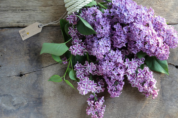 Spring beautiful bunch of purple flowers. Lilac flowers on old antique brown rustic wood background. Top view, flat lay. Banner, card, poster, rustic concept. Mothers day card