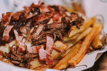 Shredded meat with minced and sauteed bacon accompanied by sautéed red onion and French fries