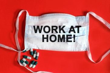 WORK AT HOME - text on a protective face mask, tablets on a red background