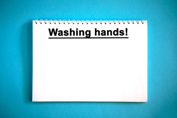 Washing hands - text on a white notebook on a blue background