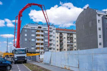 Concrete mixer truck pumping concrete on a foundation of the new building 