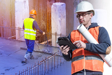 Engineer in an orange vest and hard hat on the background of the Foundation of the building. The worker evenly distributes concrete in the Foundation of the future house. Control of the construction.
