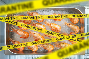 A tray of prawns behind a yellow ribbon marked Quarantine. Ban on the import of seafood. The closure of restaurants due to the coronavirus. Self-isolation. Trade restrictions.
