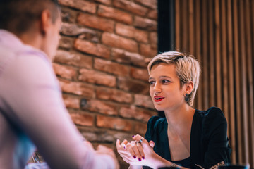 An attractive blonde with red lipstick explaining her strategy on a business meeting in a restaurant