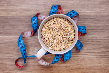 an inch for sewing blue and red around a white Cup of oatmeal on the wooden floor