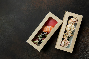Fototapeta na wymiar Beautiful gunkans and sushi for delivery on a dark background. Food delivery. Food at home. Delivery concept.