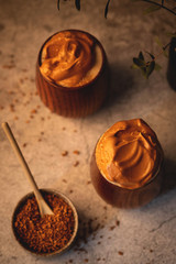 fluffy whipped coffee, dalgona coffee,vintage wooden glasses with a beverage, trend korean drink