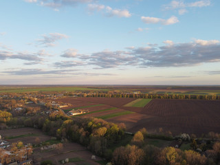 Naklejka premium Evening sunshine over the Ukrainian village, trees and small areas of land and fields in agriculture.