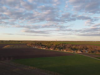 Landscape with plots in agriculture. Evening over village in spring.