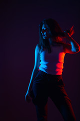 Blue and red light portrait of a female model on a black background with high contrast