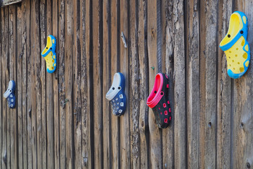 Old rubber shoes on a wooden wall.