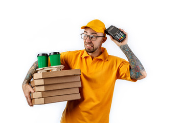 Friendly young man from a courier delivery service holds in his hands boxes of pizza and a terminal for cashless payments on a white background