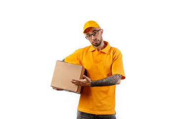 Friendly young delivery man holding big boxes in his hands on a white background