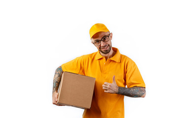 Friendly young delivery man holding big boxes in his hands on a white background