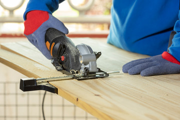 Carpintero cortando madera con sierra electrica