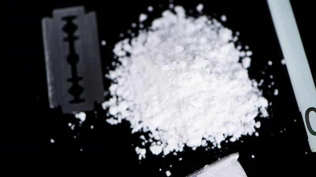Portion of rotating Cocaine on a dark plate (seamless loopable)