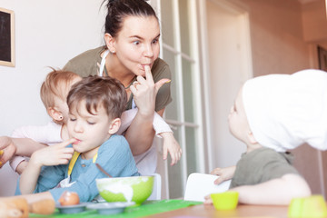 Obraz na płótnie Canvas happy mom prepares a pie with children, entertains children on maternity