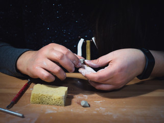 Girl making ceramic jewelry by hand