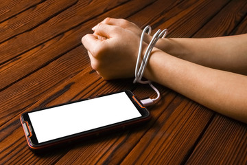 a phone with hands addiction on a wooden background