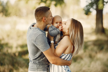 Family with cute little son. Father in a gray shirt. Lady in a dress