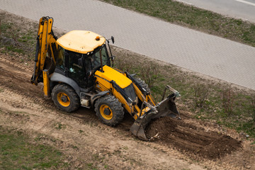 Above view of tractor doing earthwork in spring. Above view