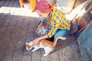 Woman petting the cat on the farm
