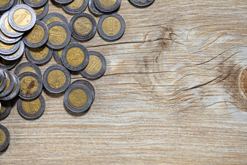 Mexican pesos on wood texture background