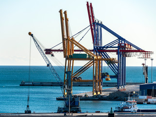 Fototapeta na wymiar Container Cranes in a small port in Spain