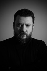 Black and white studio portrait of brutal bearded man in turtleneck