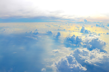 Sun rise in the morning of blue sky above the white clouds and land looking through an airplane window