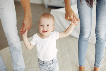 Cute family in a room. Lady in a white shirt. Little boy with parents