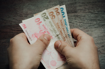 Many hundred Turkish lira on wooden table background texture. bundles of money scattered on the office desk. wealth and income concept. Counting money. 