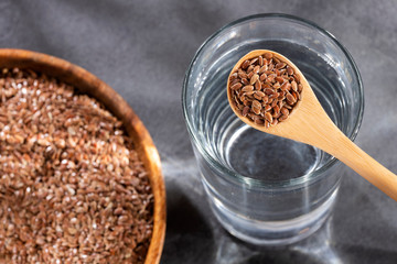 Spoon with flaxseeds to mix with water - Linum usitatissimum - obrazy, fototapety, plakaty