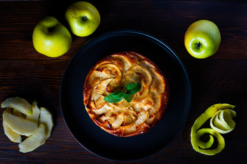 apple pie on a rustic background in a zenith view and surrounded by ingredients