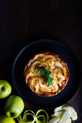 apple pie on a rustic background in a zenith view and surrounded by ingredients