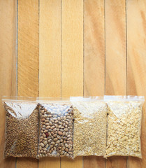 bags of beans,buckwheat, barley and oatmeal are on a wooden table, top view. the concept of food delivery to home