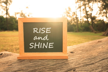 Inspiration and creative concept: Blackboard written " Rise And Shine " at outdoor with natural lights, selective focus