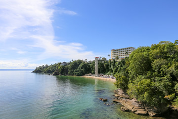 
Sea Caribbean landscape in Dominican republic with palm trees, sandy beach, green mountains, rocks, blue sky and turquoise water 