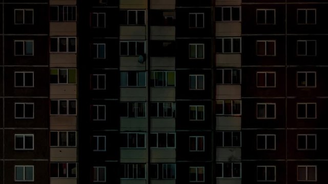 dimming light in the window of an apartment building at night.  life in a big city. Owl man