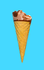 side view chocolate flavor ice cream cone with a bite on a blue background