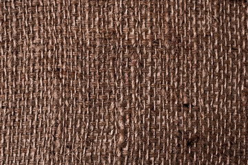 A canvas napkin lying on a wooden surface, rustic upholstery. Background for fall and natural objects. old rough brown burlap texture for wallpaper design